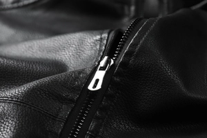 Macro detail of high-quality black litchi grain leather and durable silver metal zipper