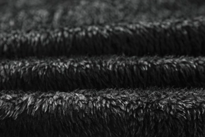 Close-up macro view of thick black faux fur lining for winter hooded biker jackets