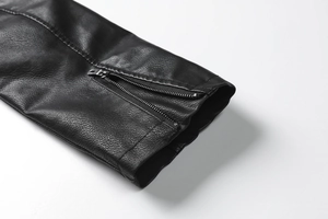 Detailed close-up of high-quality black leather texture and metal zipper on jacket sleeve