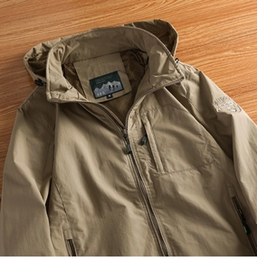 Detail of khaki outdoor jacket showing breathable mesh lining and brand embroidery