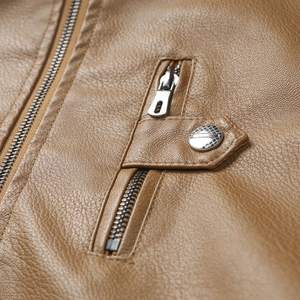 Macro view of brown leather jacket with metal zipper and engraved silver snap button detail