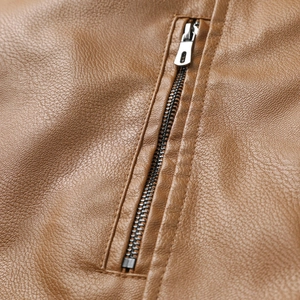 Macro detail of silver metal zipper on textured caramel brown leather jacket