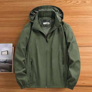 Army green men's hooded outdoor jacket with windproof fabric on a wooden background