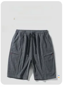 Macro detail of dark grey corduroy shorts showing elastic waist and zipper pockets