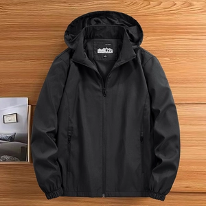 Classic men's black hooded jacket with detachable hood on a warm wood background