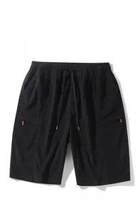 Close-up of black corduroy shorts showing textured fabric and red zipper detail