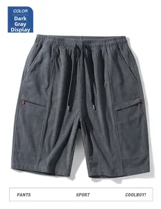 Detailed macro view of dark grey corduroy shorts with elastic waist and red zipper accents