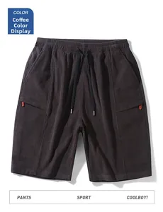 Detail of coffee brown corduroy shorts with elastic waist, drawstring and orange zipper accents
