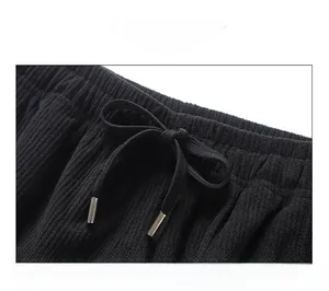 Detail of black corduroy shorts with adjustable elastic drawstring waist and metal aglets