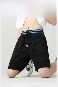 Dettaglio dei pantaloncini neri testurizzati con elastico blu a righe e coulisse in vita