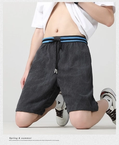 Dettaglio dei pantaloncini grigio scuro ad asciugatura rapida con texture a costine e coulisse