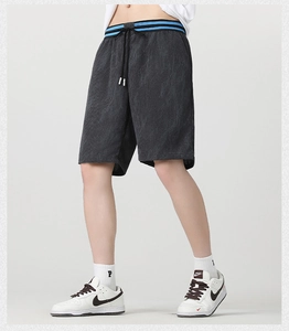 Dettaglio di pantaloncini in velluto a coste grigio scuro con texture e vita elastica a righe