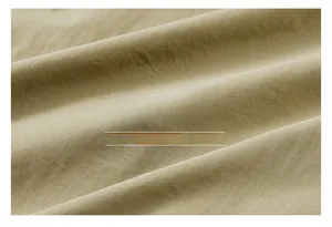 Detailed close-up of breathable beige cotton jacket fabric with fine texture and soft feel