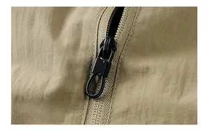 Makroaufnahme des mattschwarzen Reißverschlusses und Schiebers an einer Khaki-Jacke