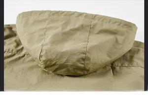 Detail of the hooded design on a khaki windbreaker showing durable stitching and fabric