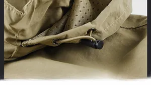 Detail of khaki outdoor jacket featuring adjustable drawstring toggles and mesh lining