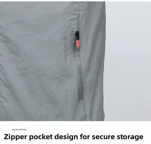 Detail of grey ice silk jacket featuring a secure zipper pocket with orange pull cord