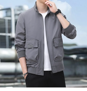 Close-up of grey outdoor jacket featuring stand collar, metal zipper, and large utility pockets