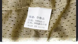 Detail shot of khaki mesh fabric with wash care label showing 100% nylon composition