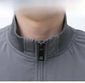 Macro detail of men's hiking jacket stand-up collar and premium metal zipper closure