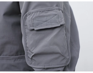 Detailed close-up of tactical cargo pocket with reinforced stitching on gray jacket