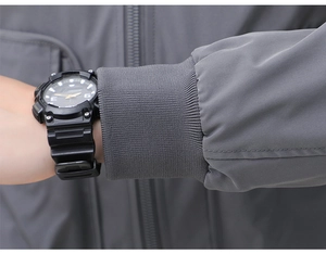 Detailed view of gray outdoor jacket sleeve with windproof ribbed cuff and sports watch