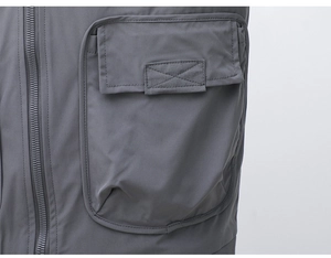 Close-up of a deep grey outdoor jacket showing a cargo pocket and zipper detail