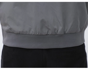 Detailed macro view of the grey outdoor jacket ribbed hem and fabric texture finish