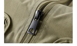 Macro shot of high-quality zipper and durable olive fabric texture on men's flight jacket