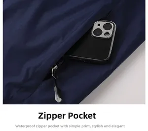 Detailed close-up of a waterproof zipper pocket on a dark blue outdoor jacket with a phone