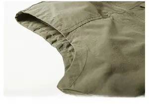 Detail of army green outdoor vest showing reinforced double-stitch armhole seams