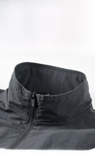 Detailed macro view of men's dark grey jacket collar with zipper and inner size label