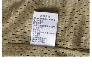 Macro shot of the laundry care label on the quick-dry mesh fabric of the khaki vest