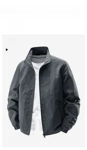 Detail of dark gray windbreaker jacket featuring stand collar and elastic cuffs
