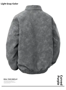 Detail view of the back of a light grey distressed faux suede jacket with ribbed hem