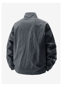 Rear view of dark charcoal lightweight windbreaker with stand collar and elastic cuffs