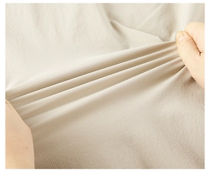 Macro view of high elasticity beige fabric showing fine vertical texture and stretch performance