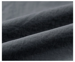 Detailed close-up of dark grey functional fabric texture for men's outdoor jacket