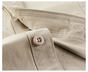 Detail of reinforced stitching and resin button on khaki workwear shirt fabric