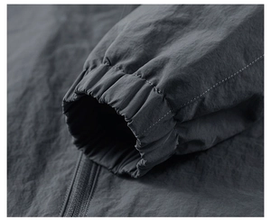 Detailed close-up of elastic cuffs and zipper on a dark gray outdoor sport jacket