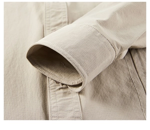Close-up detail of beige long sleeve shirt showing fabric texture and stitching