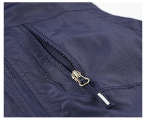 Detail of navy blue vest showing synthetic fabric texture and horizontal zipper pocket