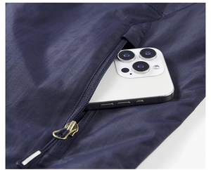 Detail shot of the deep blue vest showing a side zipper pocket holding a large smartphone