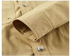 Detail of khaki quick-dry shirt featuring textured fabric, neat stitching and resin buttons