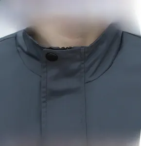 Dettaglio della giacca grigio scuro a collo alto con chiusura a zip e bottoni
