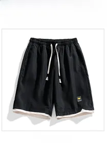 Detail of men's quick-dry black shorts featuring elastic waist and layered hem design
