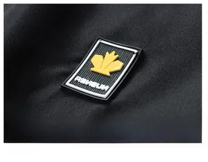 Close-up of black quick-dry fabric featuring a rectangular rubber logo with yellow leaf
