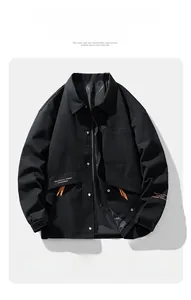 Detail of men's casual black jacket showing snap buttons and slogan print on the hem