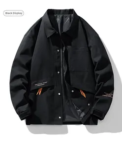 Detail view of black utility jacket featuring orange accents and chest pocket details