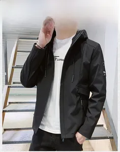 Detailed view of black hooded jacket with decorative arm strap and zip front for men